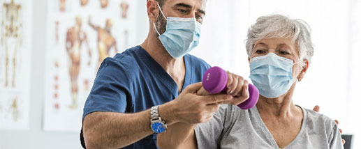 A provider helps rehabilitate an elderly woman's shoulder with a weight routine