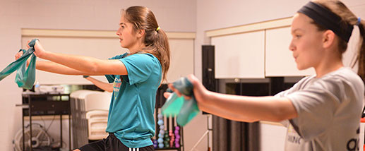 Two teenage girls exercise at a Trinity Elite facility