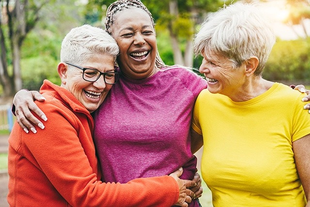 Three women embracing outside